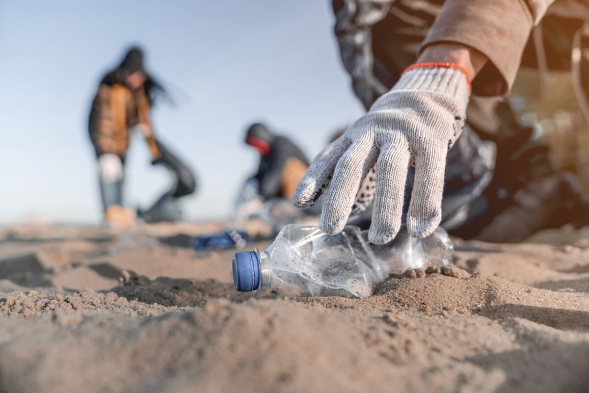 Volunteer man collecting trash on the beach Ecology concept