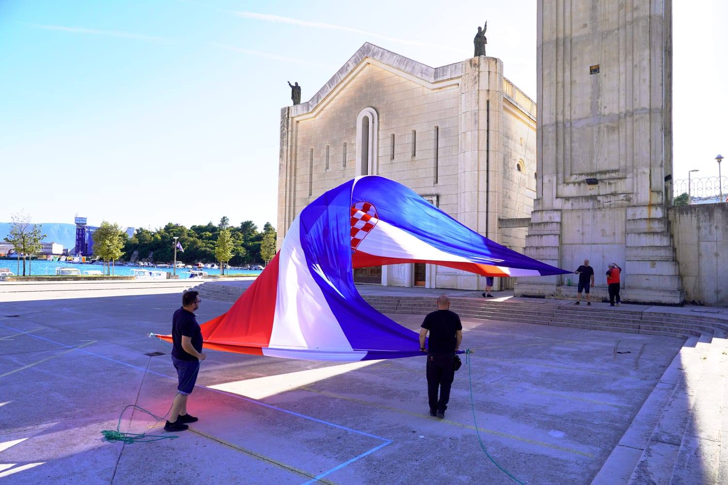 FOTOGALERIJA Velika hrvatska zastava na zvoniku crkve Kraljice Neba i Zemlje u Pločama povodom Dana državnosti